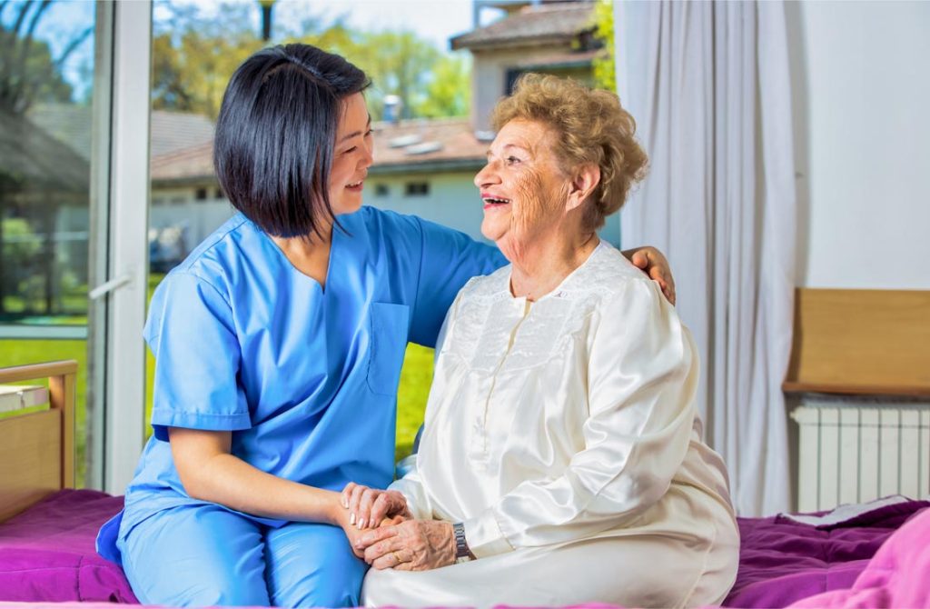 nurse consoling an elderly woman who just woke up in her home
