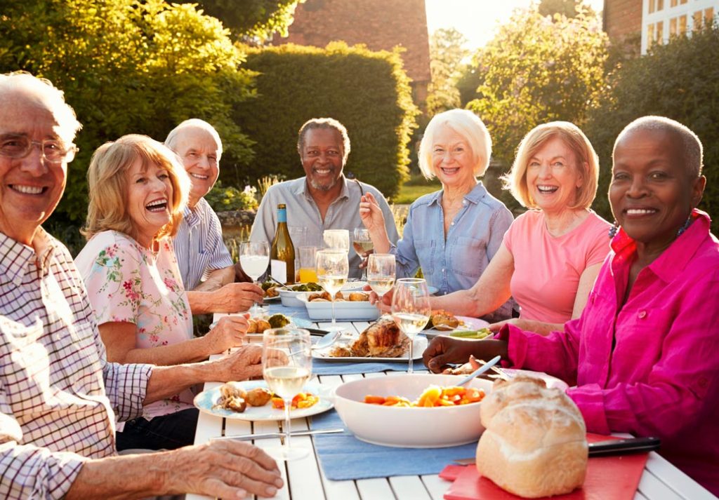 senior residents enjoying dinner together outside